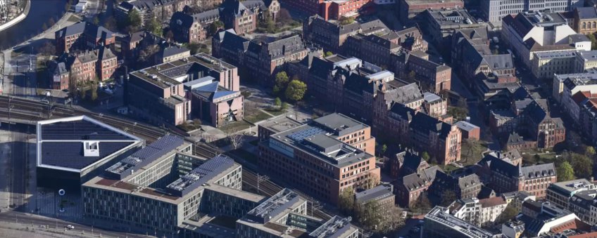 Aerial view of the Max Planck Institute for Infection Biology with a view of the brick buildings of the historic Charité campus and the S-Bahn tracks.